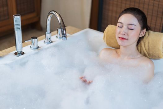 beautiful woman relaxing with eyes closed in bathtub