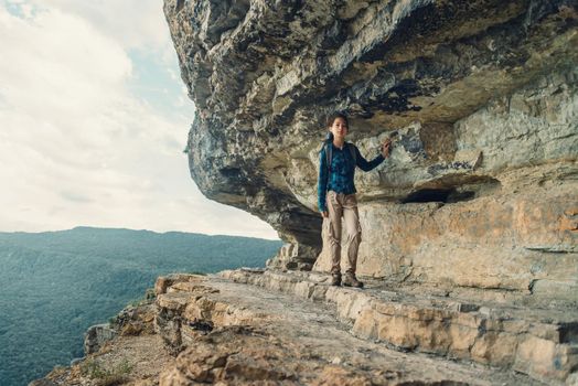 Traveler young woman walking near high cliff named Eagle shelf, town Mezmay, Russia