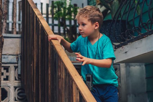 Copy Space lifestyle boy move go wood stairs look far away outside hold handrails, intrigue play facial expression, hide seek. Concept carefully search new expect, education children kid goods games.