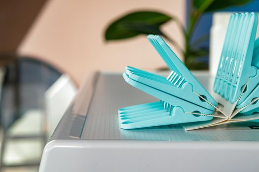 Blue clothes pins on white washing machine, close up