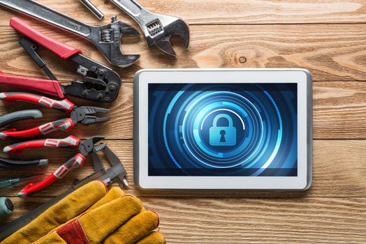 Tablet pc with security concept on screen and industrial tools around