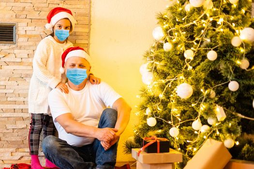 People with gifts wearing facemasks during coronavirus and flu outbreak on Christmas. Virus and illness protection, home quarantine. COVID-2019.