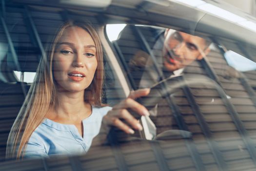 Attractive young woman sitting in new car in showroom close up