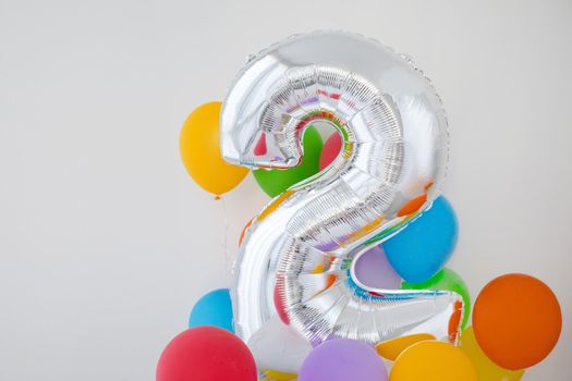 Number 2 two of color balloon on a light background. Birthday balloon for baby with , rainbow color- red, orange, yellow, green, sky blue and fiolet balloons