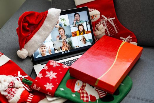 Family online video conference, christmas greetings. Virtual call through screen of laptop, gift. Remote conversation with mom, wife, children. Home isolation.