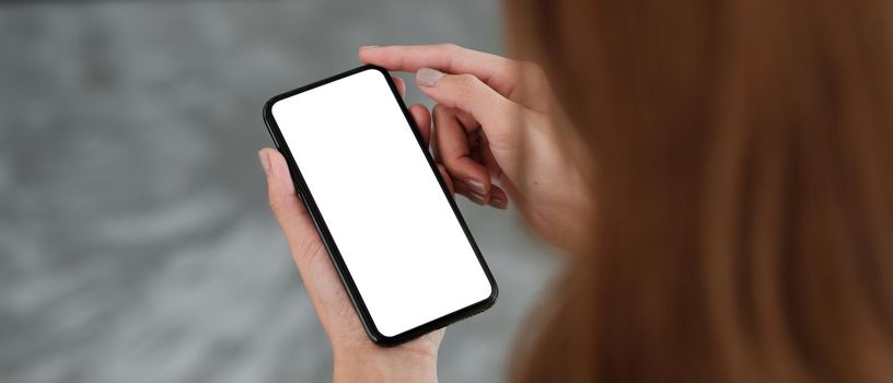 Top view Woman sitting and holding blank screen mock up mobile phone.