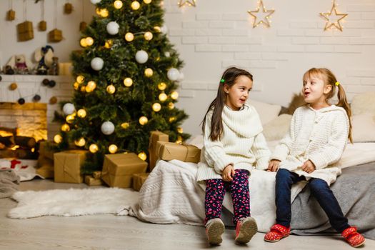 two little girls Sharing a Surprise on Christmas Morning.