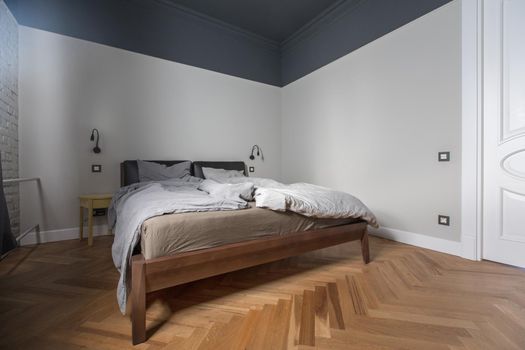 Interior of modern bedroom with unmade bed at home.