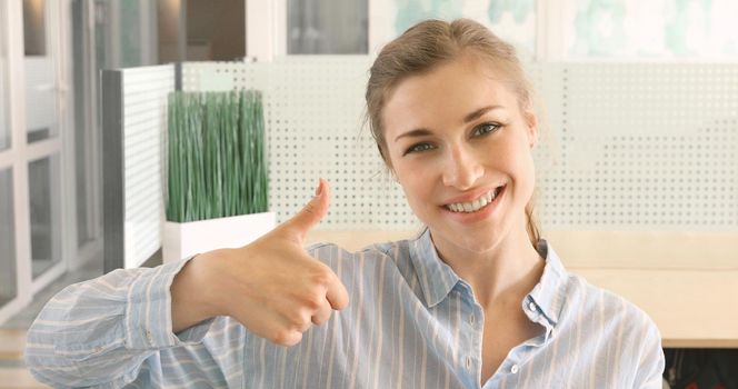 Cheerful girl showing thumb up smiling. Woman smiles shows good gesture