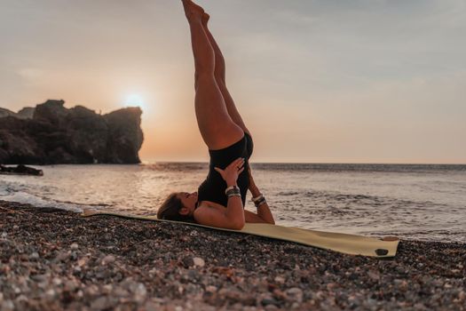 Young woman in swimsuit with long hair practicing stretching outdoors on yoga mat by the sea on a sunny day. Women's yoga fitness pilates routine. Healthy lifestyle, harmony and meditation concept.