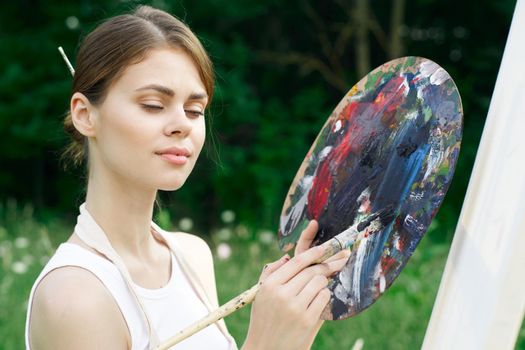 woman artist nature paints palette easel creative landscape. High quality photo