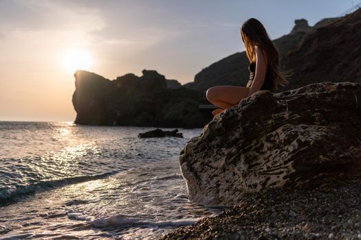 Young woman in swimsuit with long hair practicing stretching outdoors on yoga mat by the sea on a sunny day. Women's yoga fitness pilates routine. Healthy lifestyle, harmony and meditation concept.