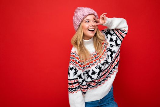 Beautiful positive happy young blonde woman isolated over colourful background wall wearing casual stylish clothes feeling sincere emotions looking to the side.