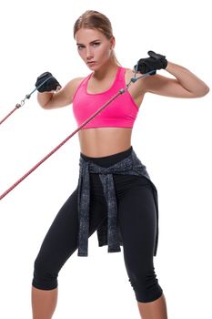 Strong woman using a resistance band in her exercise routine. Young woman performs fitness exercises on white background. Woman with beautiful slim healthy body posing in studio.