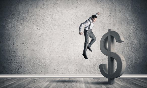 Young furious businessman going to crash with fist stone dollar symbol