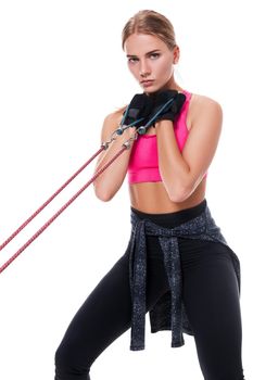 Strong woman using a resistance band in her exercise routine. Young woman performs fitness exercises on white background. Woman with beautiful slim healthy body posing in studio.