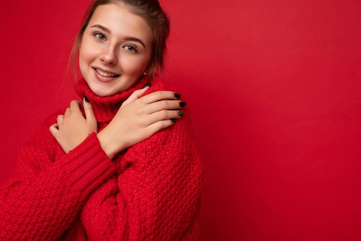 Closeup photo of young pretty brunette woman with sincere emotions isolated on background wall with copy space wearing trendy red sweater. smile and happy concept.