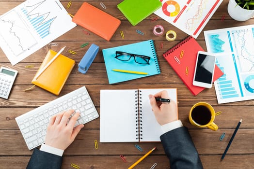 Businessman hands working at vintage wooden desk. Office workspace with computer keyboard and supplies. Business occupation concept with man in business suit. Innovation and digital technology.