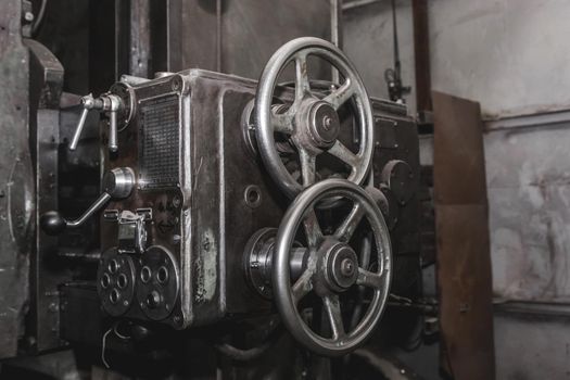 Iron round handles of the old milling machine of equipment and tools for metal processing in the workshop of the industrial plant.