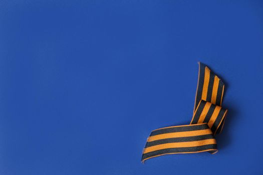 Tver Russia-may 9, 2020: 75 years of Victory in the great Patriotic war. St. George ribbon for 75 years of victory on a blue background. Happy Victory Day. Space for text.