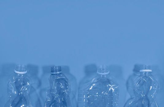 Plastic bottles isolated on deep blue background. Seamless pattern. Recycle waste management concept. Plastic Pet Bottles. Copy space