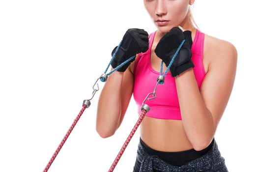 Strong woman using a resistance band in her exercise routine. Young woman performs fitness exercises on white background. Woman with beautiful slim healthy body posing in studio. Close up
