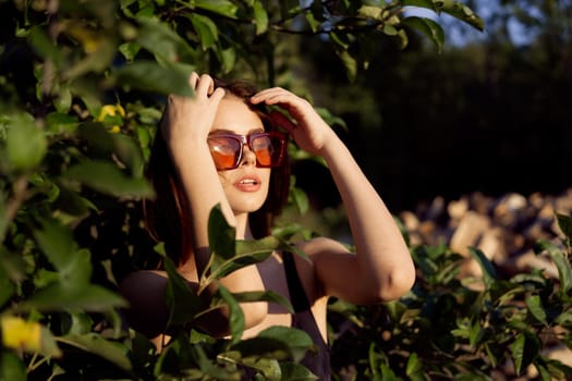 pretty woman wearing sunglasses green leaves glamor posing summer. High quality photo