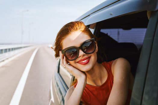 pretty woman in sunglasses rides in a travel car. High quality photo