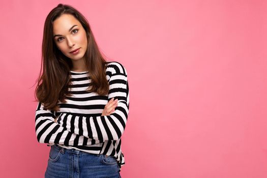 Photo shot of cute attractive pretty self-confident young brunette woman wearing casual striped longsleeve isolated over colorful background with copy space.