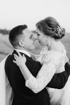 the groom and the bride walk along the wheat green field on a bright day