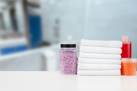 Various spa beauty threatment products and towels against blurred background, front view