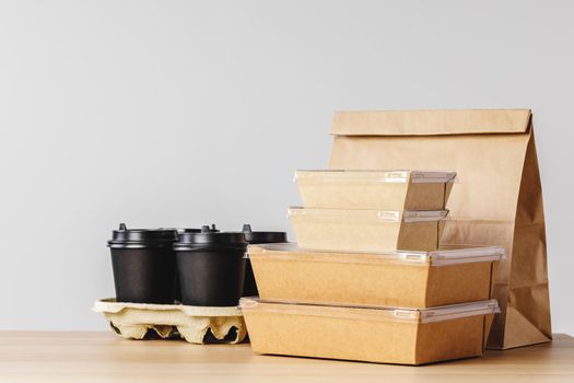 Many various take-out food containers, pizza box, coffee cups and paper bags on light grey background. Food delivery