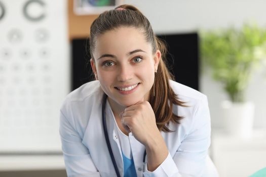 Portrait of smiling woman ophthalmologist in office of clinic. Vision test concept