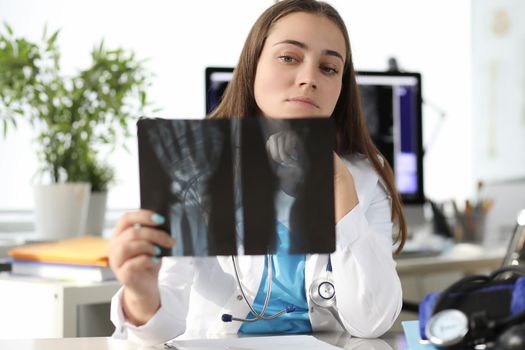 Doctor carefully examining xray of patient hand in clinic. Help with fractures concept