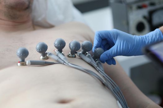 Nurse attaching suction cups to patient chest to record electrocardiogram closeup. ECG diagnostics of rhythm and conduction disorders concept