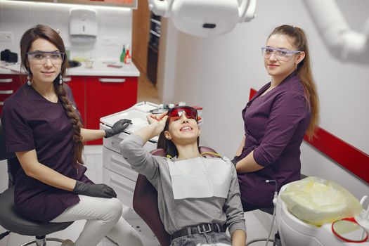 Beautiful lady in the dentist's office. Woman in a purple uniform