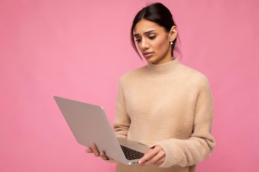 side profile photo of charming pretty sad young lady holding laptop isolated over wall background looking down at netbook.