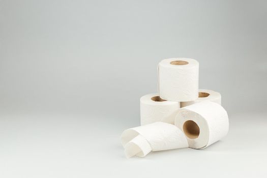 Rolls of Soft White Toilet Paper over Gray Background. Hygiene concept. Copy Space for text