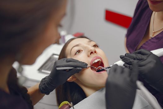 Beautiful lady in the dentist's office. Woman in a purple uniform