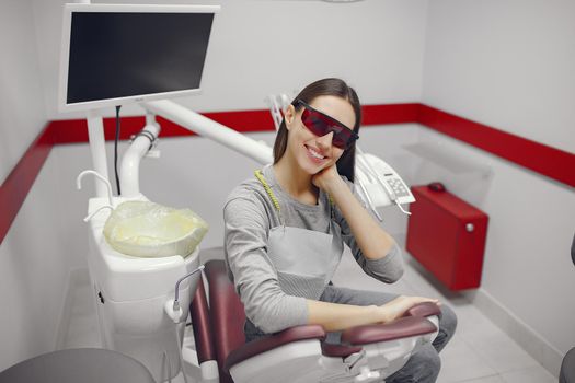 Beautiful lady in the dentist's office. Brunette sitting in a chair