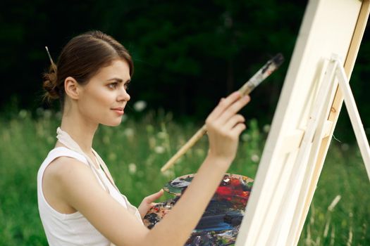 cheerful woman artist painting a picture outdoors creative art. High quality photo