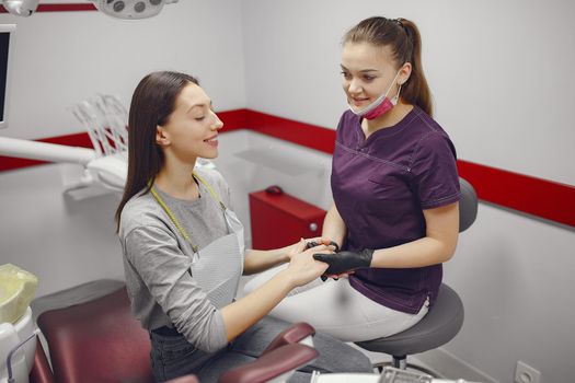 Beautiful lady in the dentist's office. Woman in a purple uniform