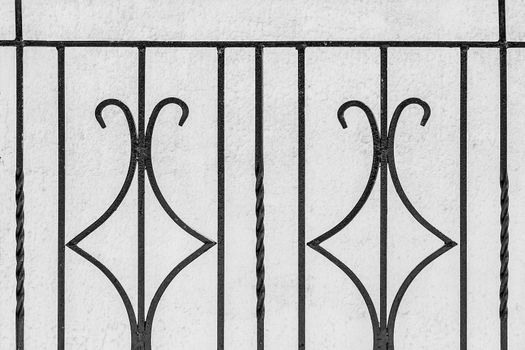 Iron black architectural geometric element, decorative fence lattic on white wall background.