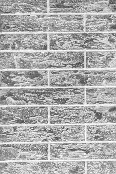 Dark grey abstract brick wall vertical texture background.