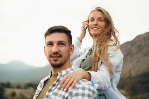 Happy couple man and woman tourists in mountains, close up