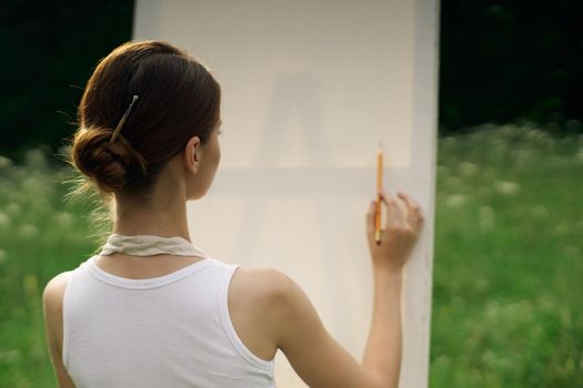 woman artist in aprons in nature draws a picture art. High quality photo