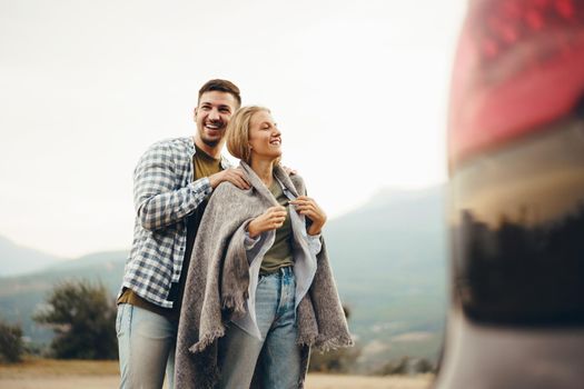 Happy loving couple hiking and hugging in mountains, close up