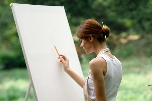 woman outdoors painting a picture easel art hobby. High quality photo