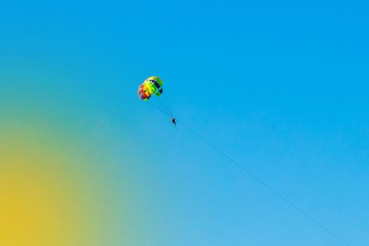 A man and a woman tourists are parachuting against the blue sky. Extreme vacation concept.