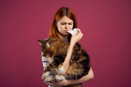 woman holding fluffy cat in her arms pet friendship pink background. High quality photo